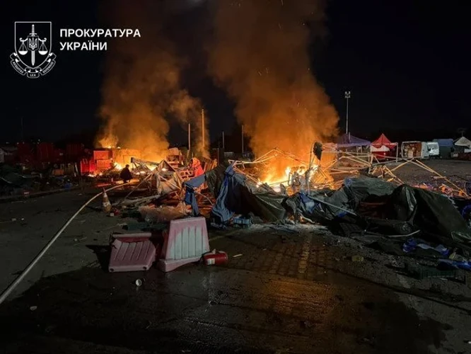 Наслідки влучання на території ринку «Столичний»: пошкоджені будівлі та територія ринку, рятувальники на місці події.